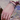 Close-up of a hand with multiple bracelets and a ring, wearing a colorful garment.