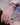 Close-up of a hand with multiple bracelets and a ring, wearing a colorful garment.