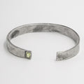 piece is a hand forged sterling cuff with a clean distressed finish and an inset emerald cut peridot gemstone