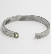 piece is a hand forged sterling cuff with a clean distressed finish and an inset emerald cut peridot gemstone