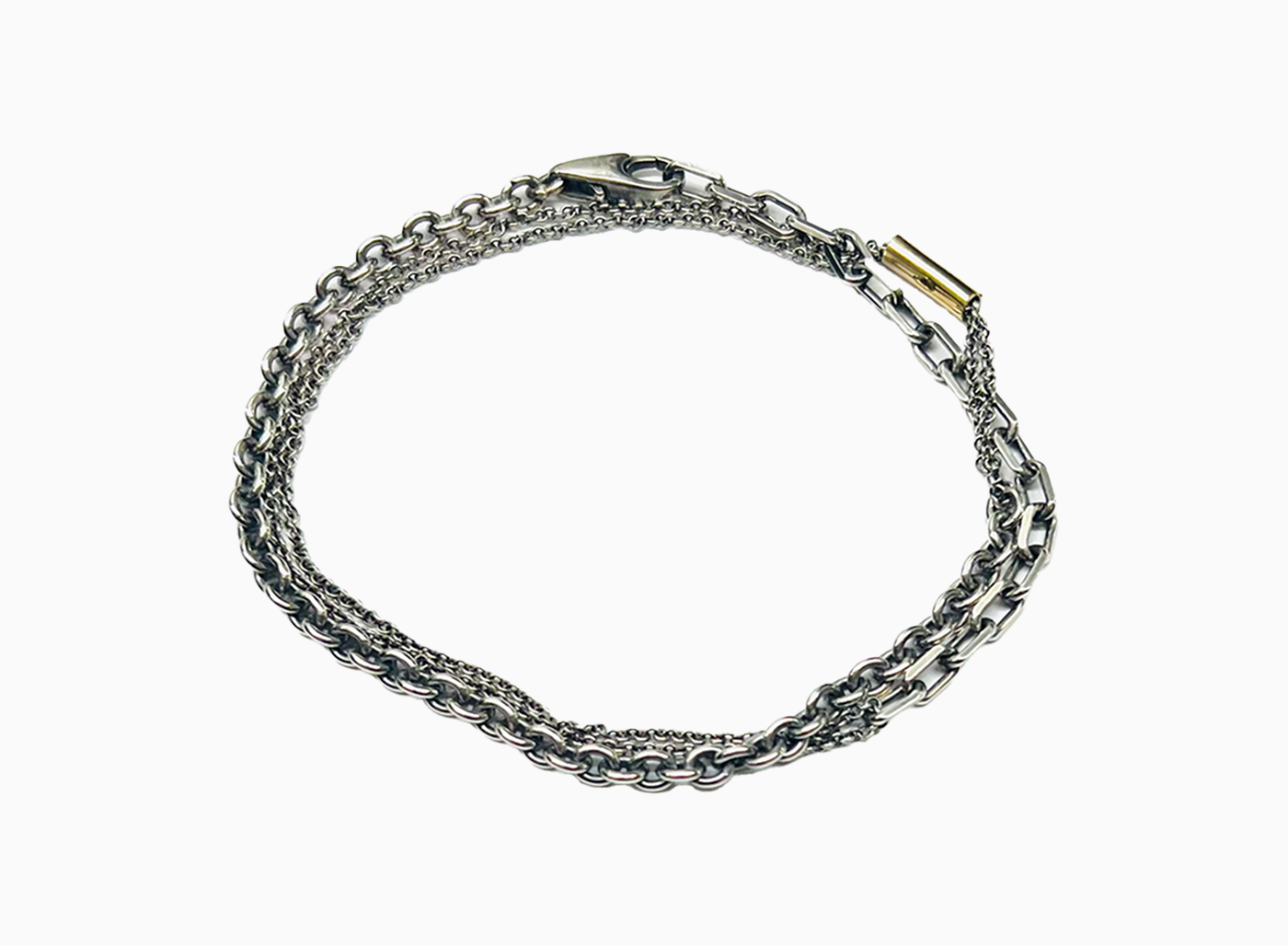 bracelet is comprised of three separate chains including a thin double strand cable chain, more dense single strand cable chain and an anchor chain, accented by an 18k yellow gold tube.
this piece can also be worn as a necklace.