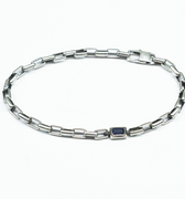 adjustable bracelet features a single offset emerald-cut iolite that sits along a sterling box chain