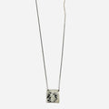 a black raw diamond is secured on this sterling pendant hanging from a beaded ball chain that is disrupted by a 1" bar