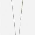 a black raw diamond is secured on this sterling pendant hanging from a beaded ball chain that is disrupted by a 1" bar