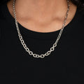 adjustable multi-chain necklace features elongated paperclip, cable, and diamond cut link chains