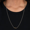 necklace is composed of a hand forged 1" solid 18k yellow gold bar that suspends from a sterling lariat and ball chain