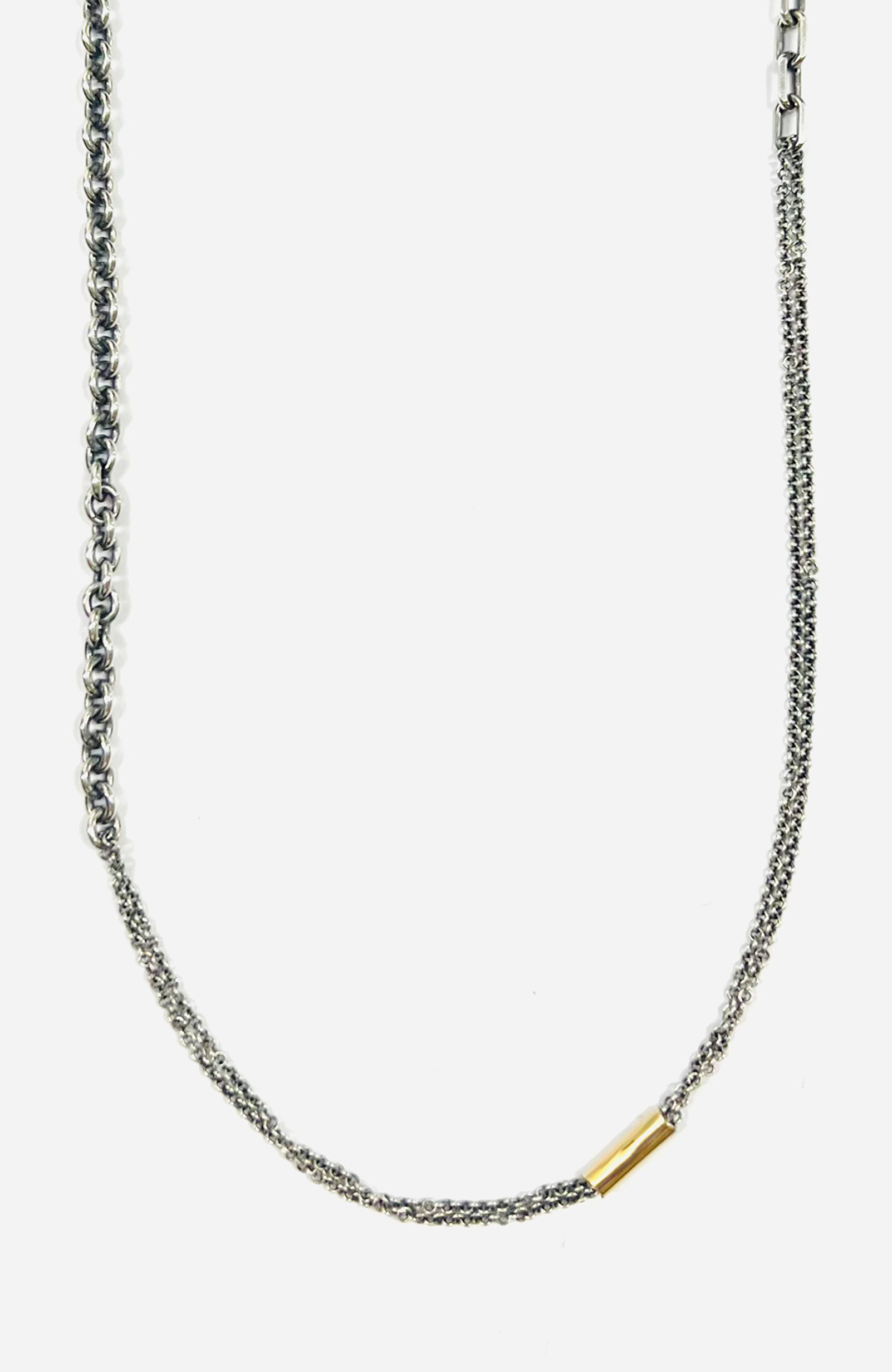 necklace is comprised of three separate chains including a thin double strand cable, more dense single strand cable and anchor chain, accented by an 18k yellow gold tube