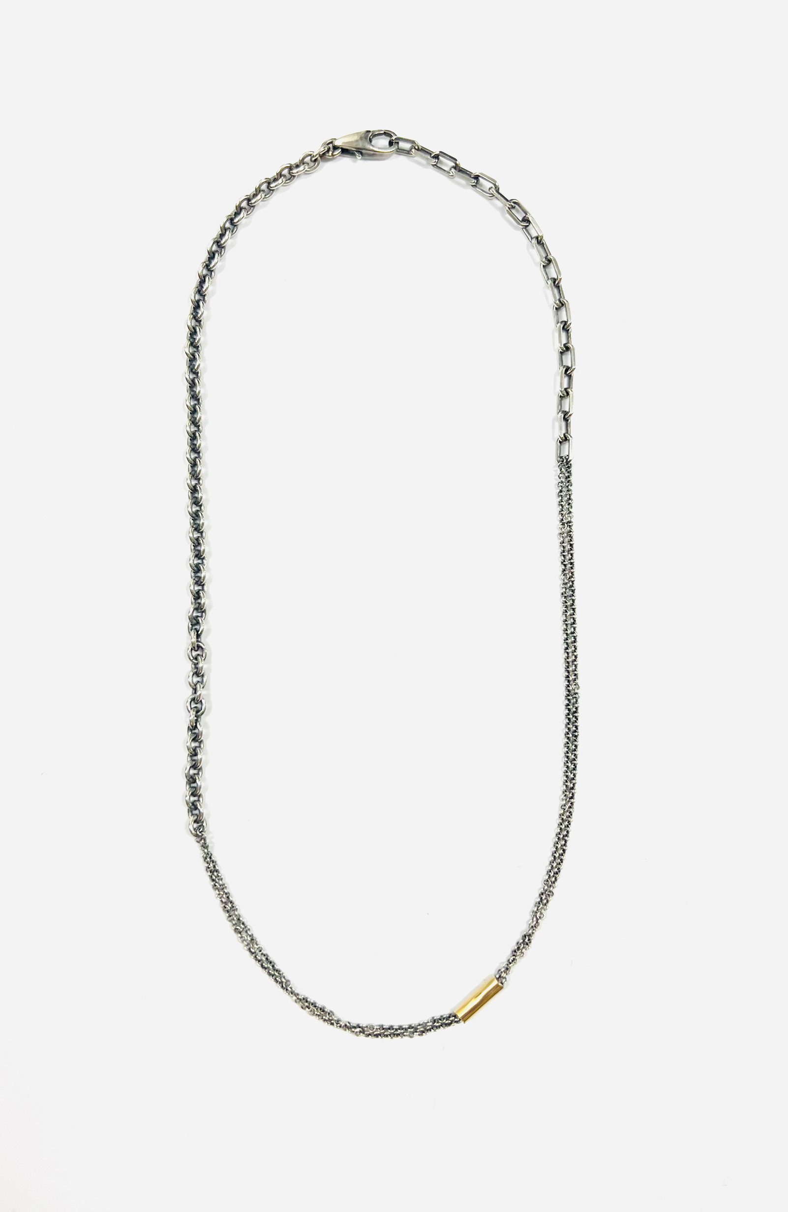 necklace is comprised of three separate chains including a thin double strand cable, more dense single strand cable and anchor chain, accented by an 18k yellow gold tube