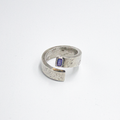 adjustable, open spiral ring features a 5mmx3mm emerald-cut iolite stone. it is hand forged and distressed for a 'worn in' look