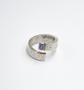 adjustable, open spiral ring features a 5mmx3mm emerald-cut iolite stone. it is hand forged and distressed for a 'worn in' look