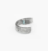 this adjustable, open spiral ring features a 7mm gemstone set within its rugged, distressed silver band. it is hand forged and distressed for a 'worn in' look