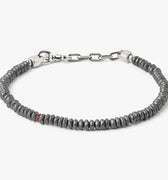 adjustable hematite stone bracelet is finished with a signature single ruby