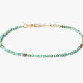 a strand of turquoise stones are accented by a single ruby and finished with 18k yellow gold links