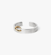 adjustable, 5mm x 2mm hand-forged open sterling ring is pierced with an 18k gold offset hoop