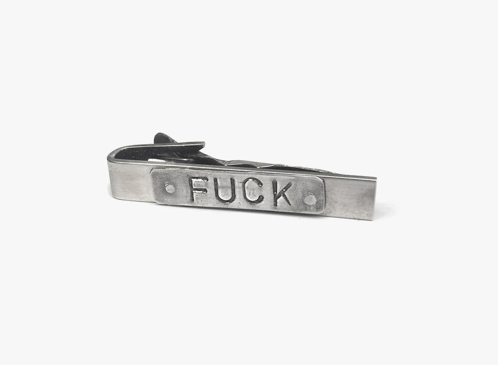 "fuck" is engraved onto an id tag that sits on this sterling tie bar